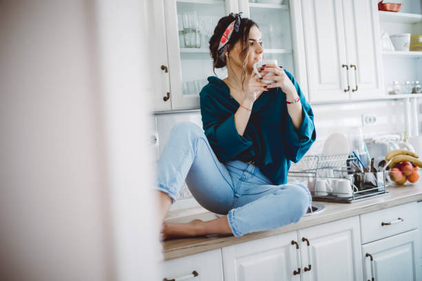 istock Young Woman drinking first morning coffee 1203498973
