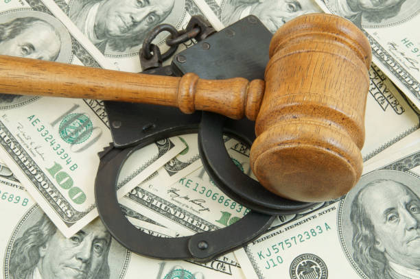 istock Gavel and handcuffs on money background 1203499055
