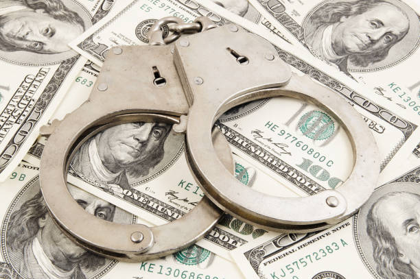 istock Handcuffs on money background 1203499138
