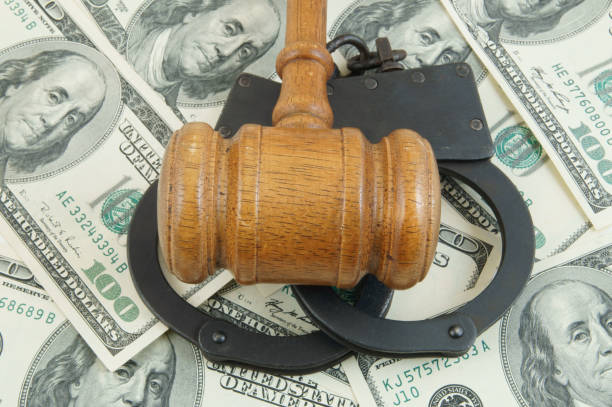 istock Gavel and handcuffs on money background 1203499157