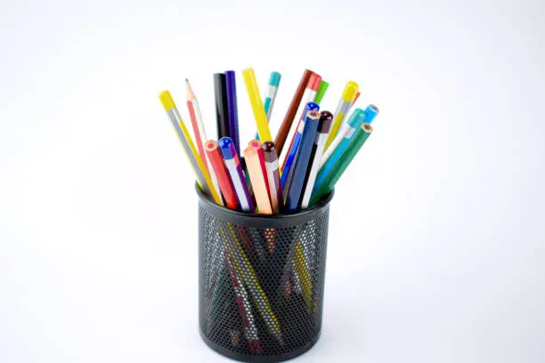 Photo of Jar full of different colored wood pencils and wax crayons on a white background