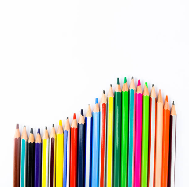 istock Colorful wood pencils arranged in a wave formation on a white background 1203503004