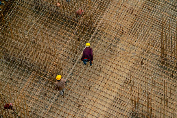 Construction workers in India standing on a rebar reinforcing bar platform making a pillar