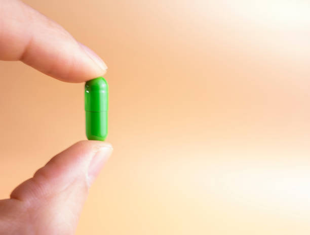 istock Holding a green capsule in your fingers 1203507287