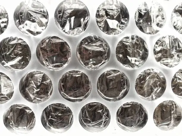 A close up bubblewrap background of the round air pockets of plastic bubble wrap in protective packaging with copy space