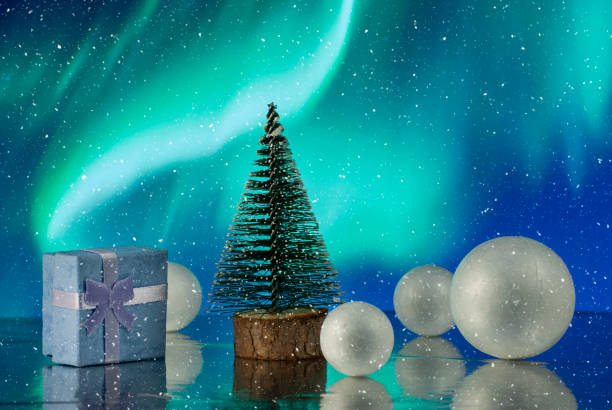 istock Christmas composition with Christmas tree, gift or present box and decorative snowballs against holiday lights 1203508279