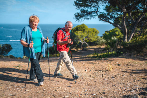 istock Active Spanish Senior Hikers Walking with Poles and Backpack 1203511174