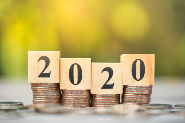 istock Wood block 2020 on coins stacks using as background new year concept. 1203511319