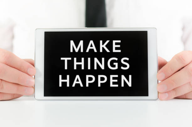 istock Businessman holding a smart tablet with sign Make things happen 1203512410