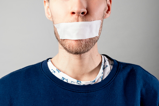 the man with a tape close his mouth, stop talking and shut down, censorship concept,