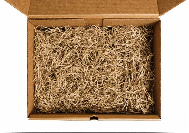 Brown shredded paper for gifting and stuffing in cardboard box. Top view.