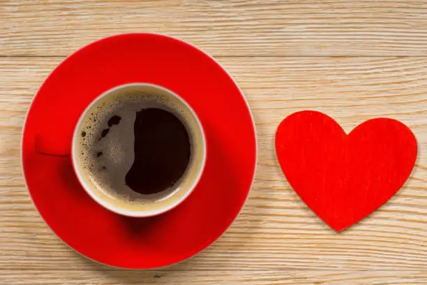 red heart shape and coffee cup on white wooden table, good morning concept