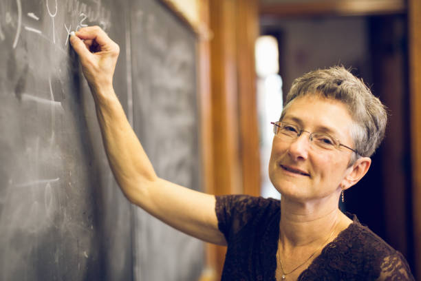 insegnante di matematica femminile senior amichevole alla lavagna - professor teacher female blackboard foto e immagini stock