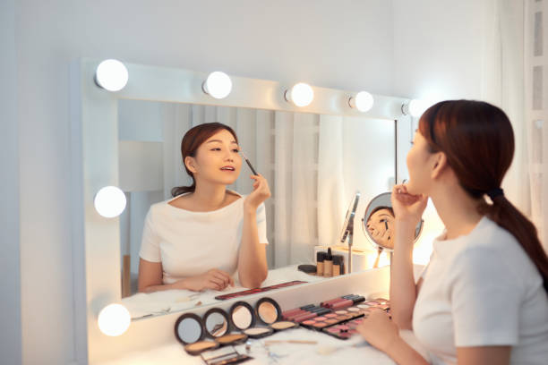 istock Reflection of young beautiful woman applying her make-up, looking in a mirror 1203520198