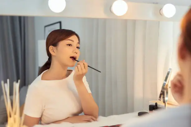 Beautiful Woman With Beauty Face Applying Lip Balm, Lipcare Stick On. Lips skincare cosmetics concept.