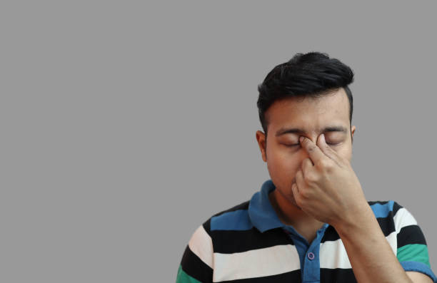 istock indonesian guy weeping in depressed mood with fingers on both eyes in grey background with copy space for .Sad mood concept 1203523820