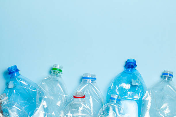 istock Crumpled plastic bottles on a blue background. Plastic trash. Copy space for text. 1203525431