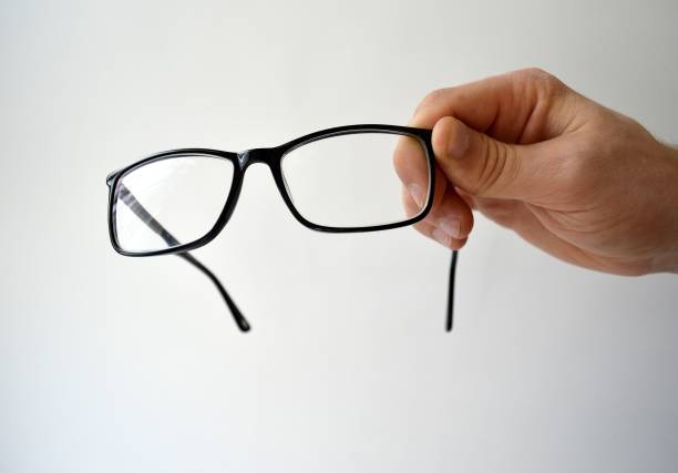 istock Black glasses in man's hand isolated on white background 1203526381