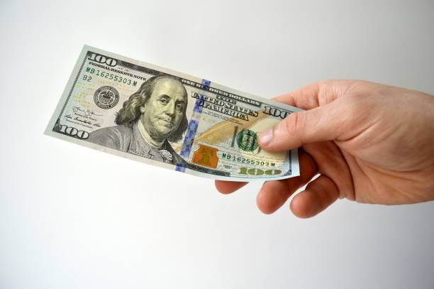 istock American dollars in hand isolated on white background 1203528835