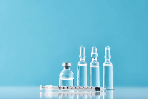 istock Syringes and medicine bottles with medication on a blue background 1203529124