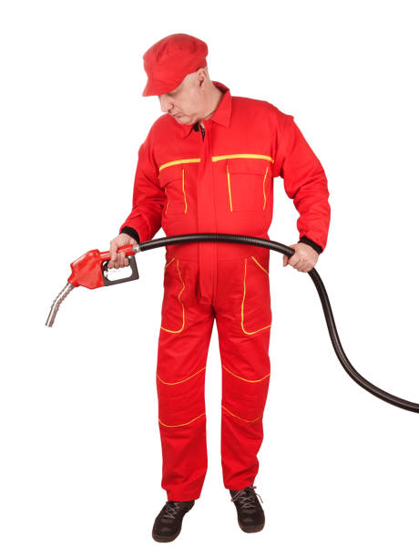 man gas station staff  is holding red gasoline pistol pump fuel nozzle - old men car oil imagens e fotografias de stock