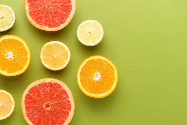 istock Colorful sliced fruits on green background with copy space 1203530052