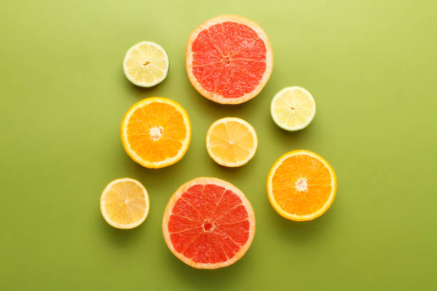istock Colorful sliced fruits on green background 1203530071