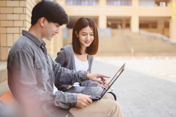 istock Education, Learning, Student, Campus, University, Lifestyle concept. Two students are sitting at the stairs reading books to education. Study for test preparation in University. 1203530509