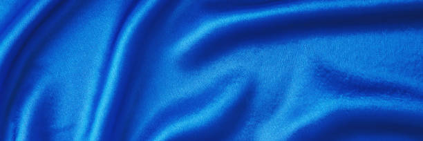 istock Blue silk background with a folds.  Abstract texture of rippled satin surface, long banner 1203532429