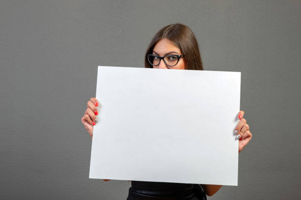 istock Beautiful woman holding a blank billboard isolated on gray background - image 1203532549