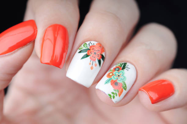 White manicure with red floral print on black background