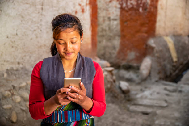 Tibetan young woman using mobile phone, Upper Mustang, Nepal