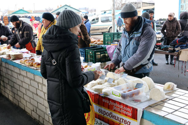Crimean Tatar, a refugee from the Crimea, sells homemade cheese in the Shpola,  center of Ukraine. Shpola, Cherkasy / Ukraine - 02 02 2020: Crimean Tatar, a refugee from the Crimea, sells homemade cheese in the Shpola,  center of Ukraine. cherkasy stock pictures, royalty-free photos & images