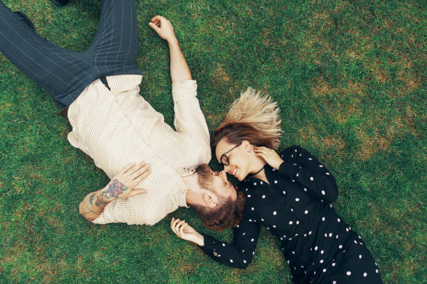 istock Couple in love lying on the grass 1203540072