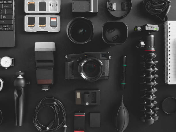 istock top view of work space photographer with digital camera, flash, cleaning kit, memory card, tripod and camera accessory on black table background 1203540758