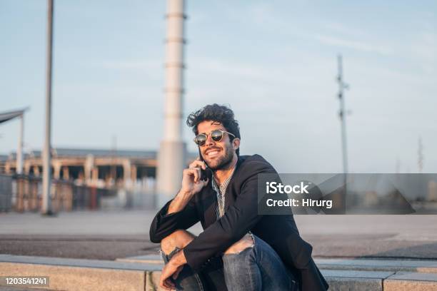 Stylish Man Talking On Smart Phone Stock Photo - Download Image Now - Business Casual, Jeans, Torn