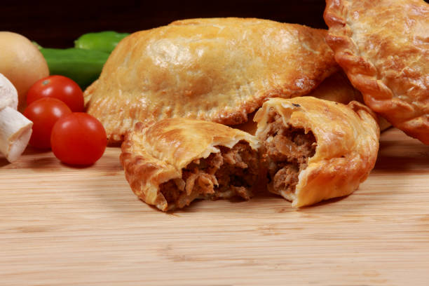 istock Freshly Baked Argentinian Recipe Empanada on cutting board 1203541375