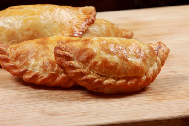 istock Freshly Baked Argentinian Recipe Empanada on cutting board 1203541378