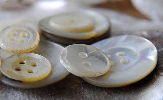 macrophotography of a heap of antique buttons made of mother-of-pearl