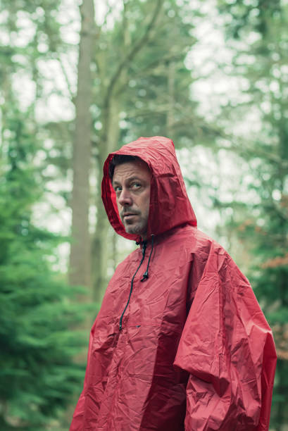 istock Man in red hooded raincoat in forest. 1203545610