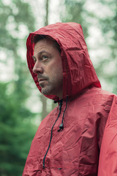 istock Man in red hooded raincoat in forest. 1203545656
