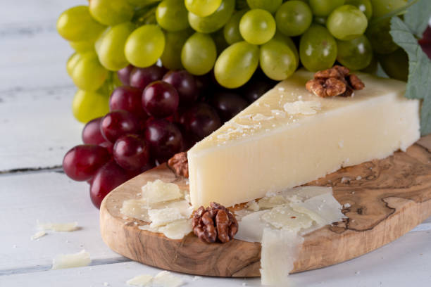 pecorino romano, formaggio di pecora duro italiano su tagliere in legno con uva, focus selettivo. spazio di copia - formaggio di pecora foto e immagini stock