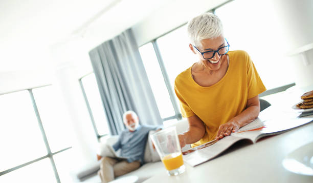 Mature couple reading newspapers and having coffee.