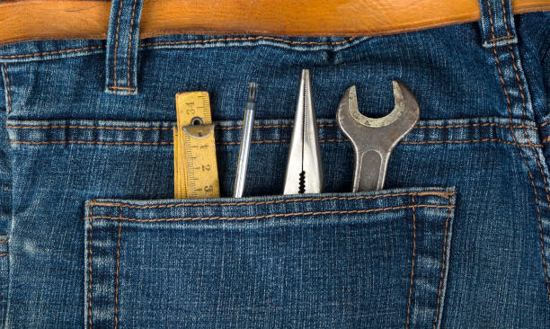 Man blue jeans back pocket with wrench meter and pencil