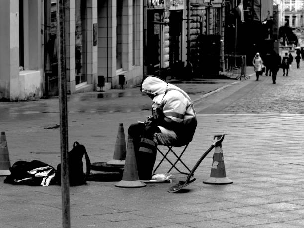 Moscow, Russia - February 01, 2020: a repairman is sitting above the open manhole on the street