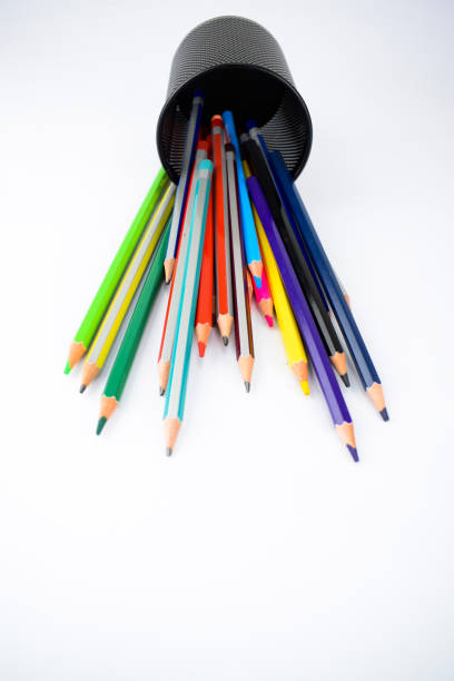 istock Top view of a jar full of different colored pencil crayons fallen on a white background 1203554751