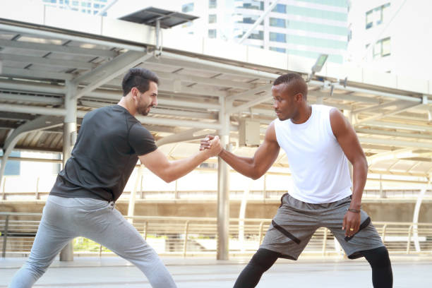 istock Partner buddy runner men help each other stretching body before exercise run outdoor, jogger athlete training and doing workout in downtown city. 1203555179