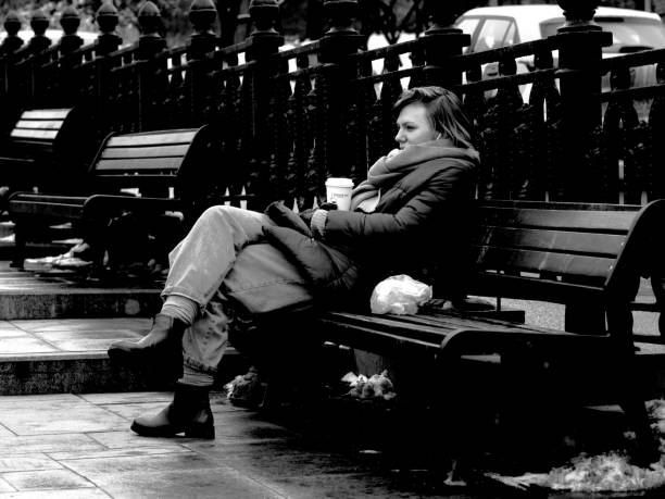 Moscow, Russia - February 01, 2020: a young woman is sitting on the bench with a cup of coffee