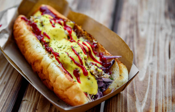 istock Philly cheese steak sandwich with meat, vegetables, cheese and sause in box on wooden table. street food 1203556785
