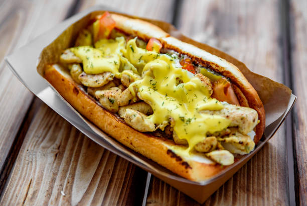 istock Philly cheese steak sandwich with meat, vegetables, cheese and sause in box on wooden table. street food 1203556790
